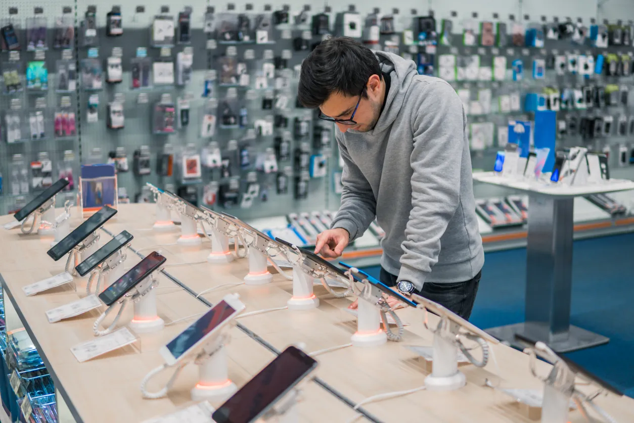 Hombre eligiendo celular en una tienda de celulares