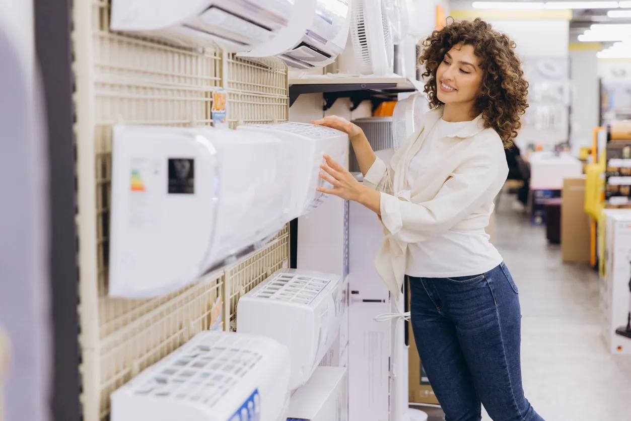 Mujer joven comprando un aire acondicionado en tienda especializada