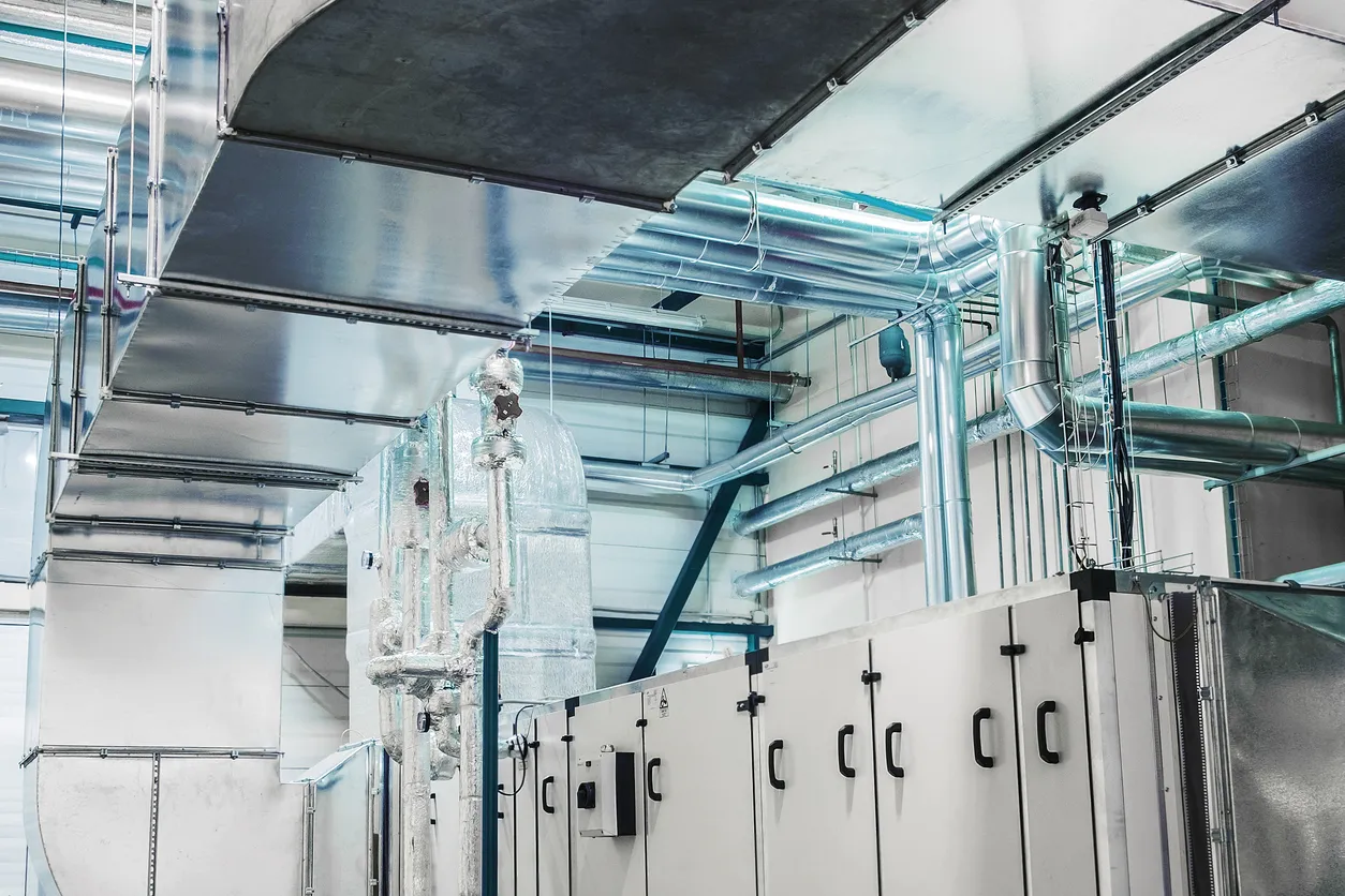 Vista lateral de la enorme unidad de manejo de aire industrial en la sala de ventilación de la planta.