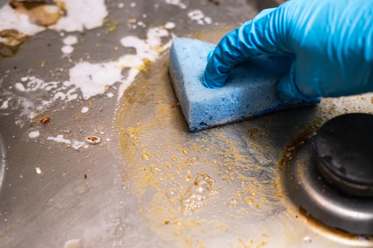 Estufa sucia con restos de comida. Cocina de gas sucia con manchas de grasa, restos de grasa vieja, restos de frituras 