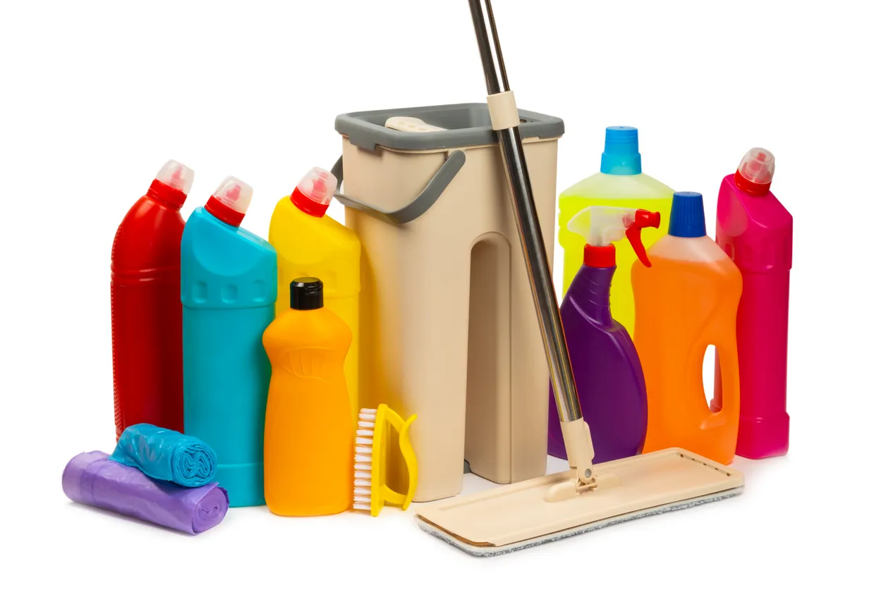 Fregona de plástico y cubo con productos de limpieza aislados sobre fondo blanco.