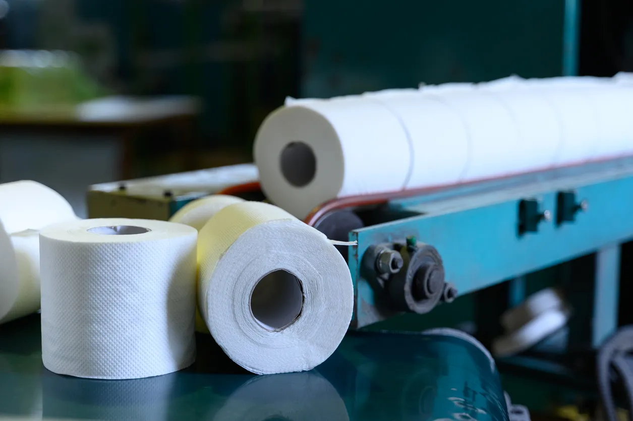 Rollos de papel higiénico en movimiento por la cinta transportadora. Antigua fábrica griega de rollos de papel higiénico