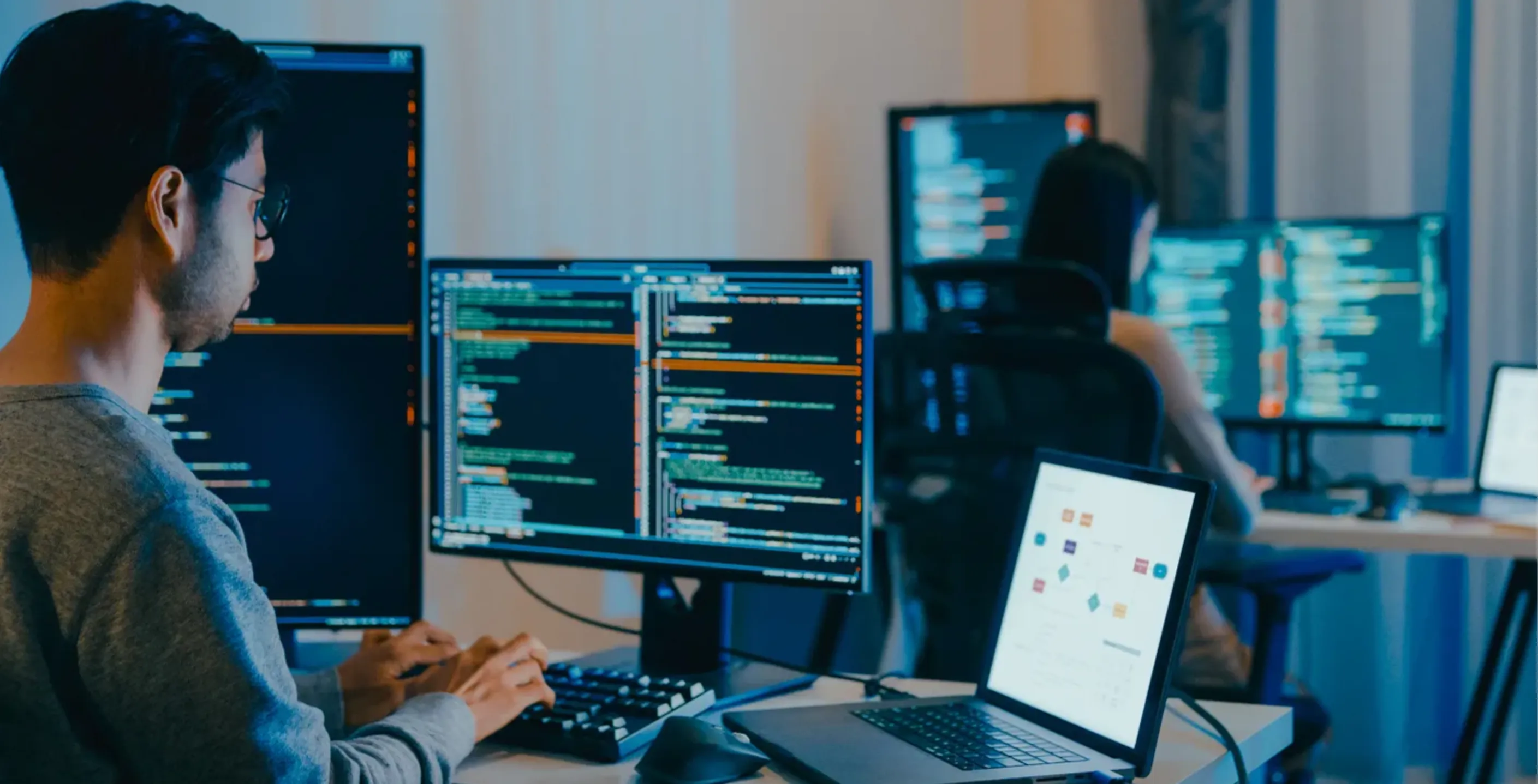 Una persona programando en varias computadoras