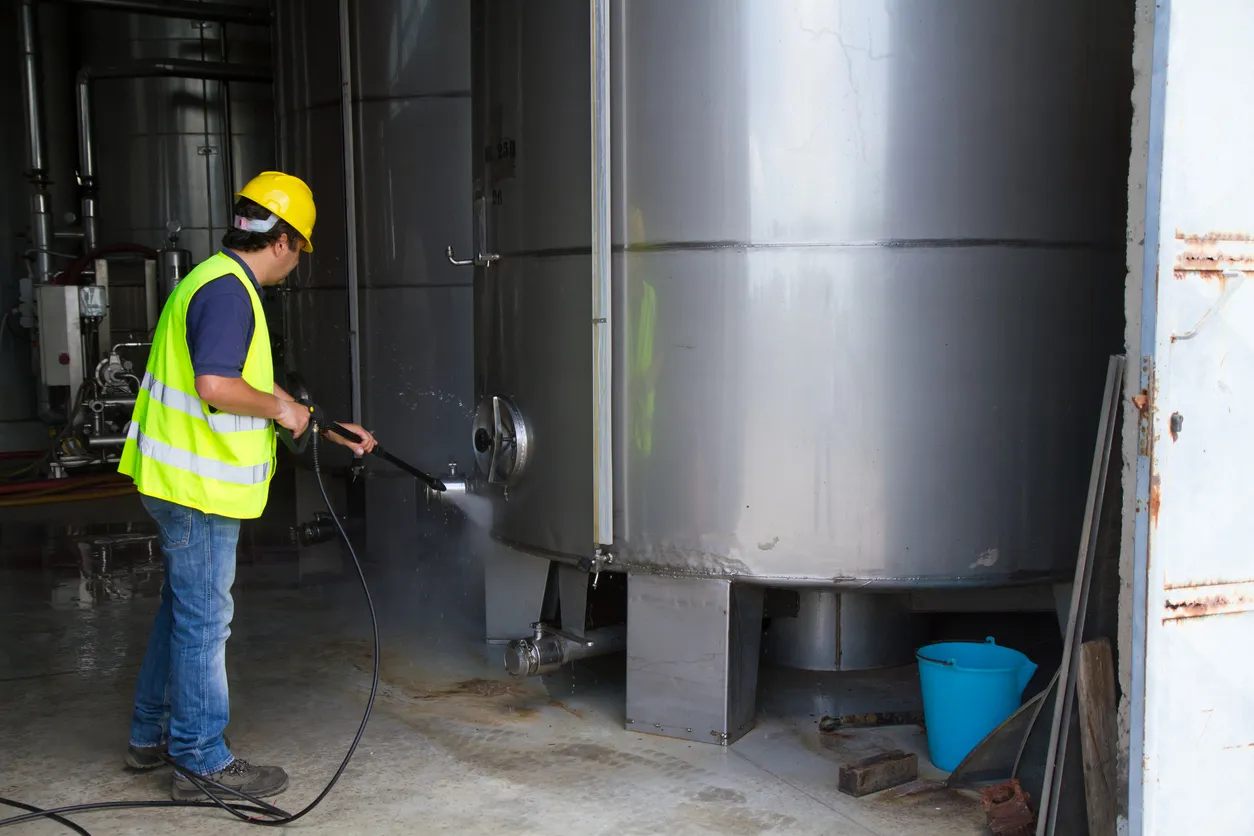 Hombre lavando alrededor del sitio industrial