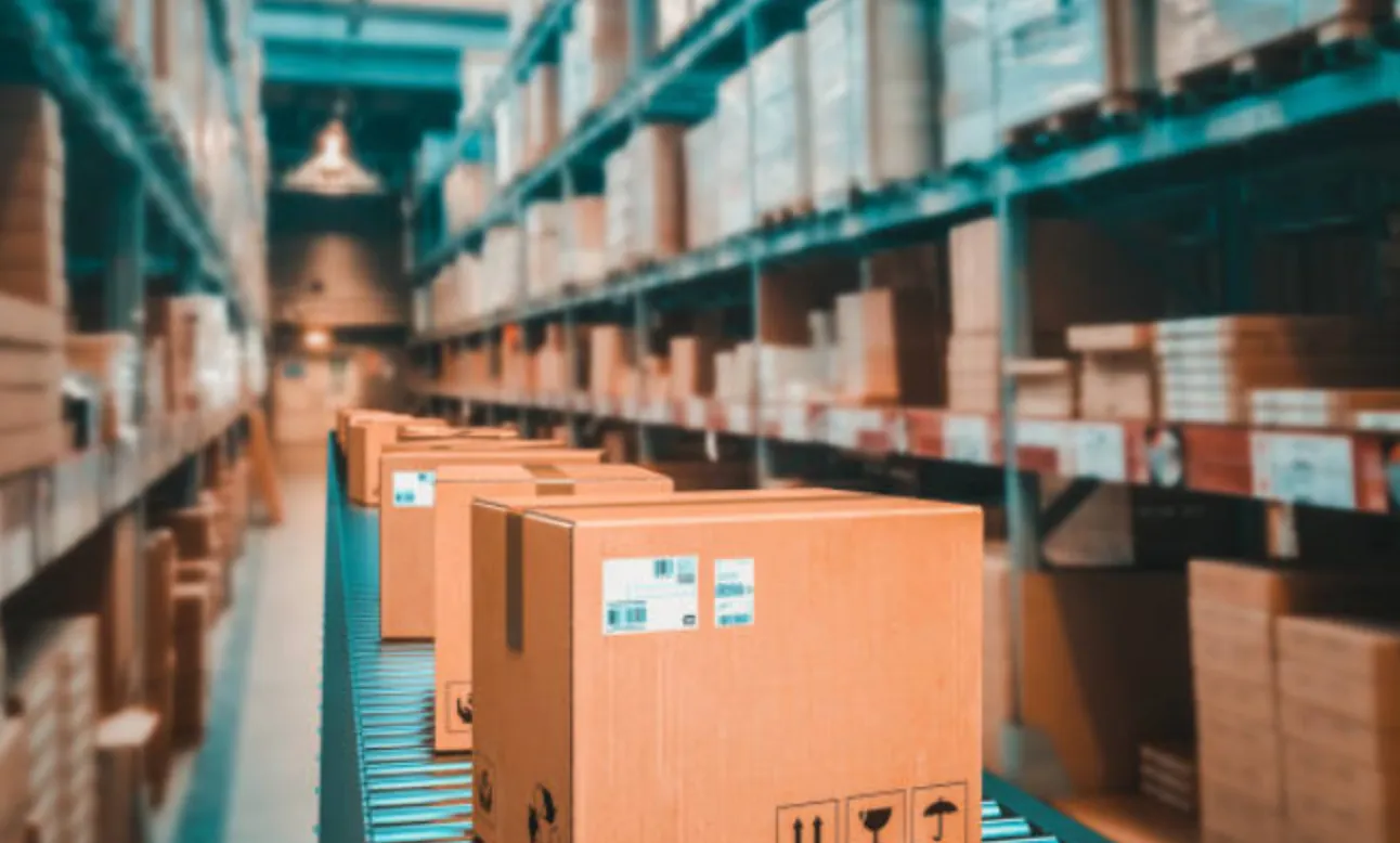 Cajas siendo transportadas por una cinta en una fábrica para ser guardadas