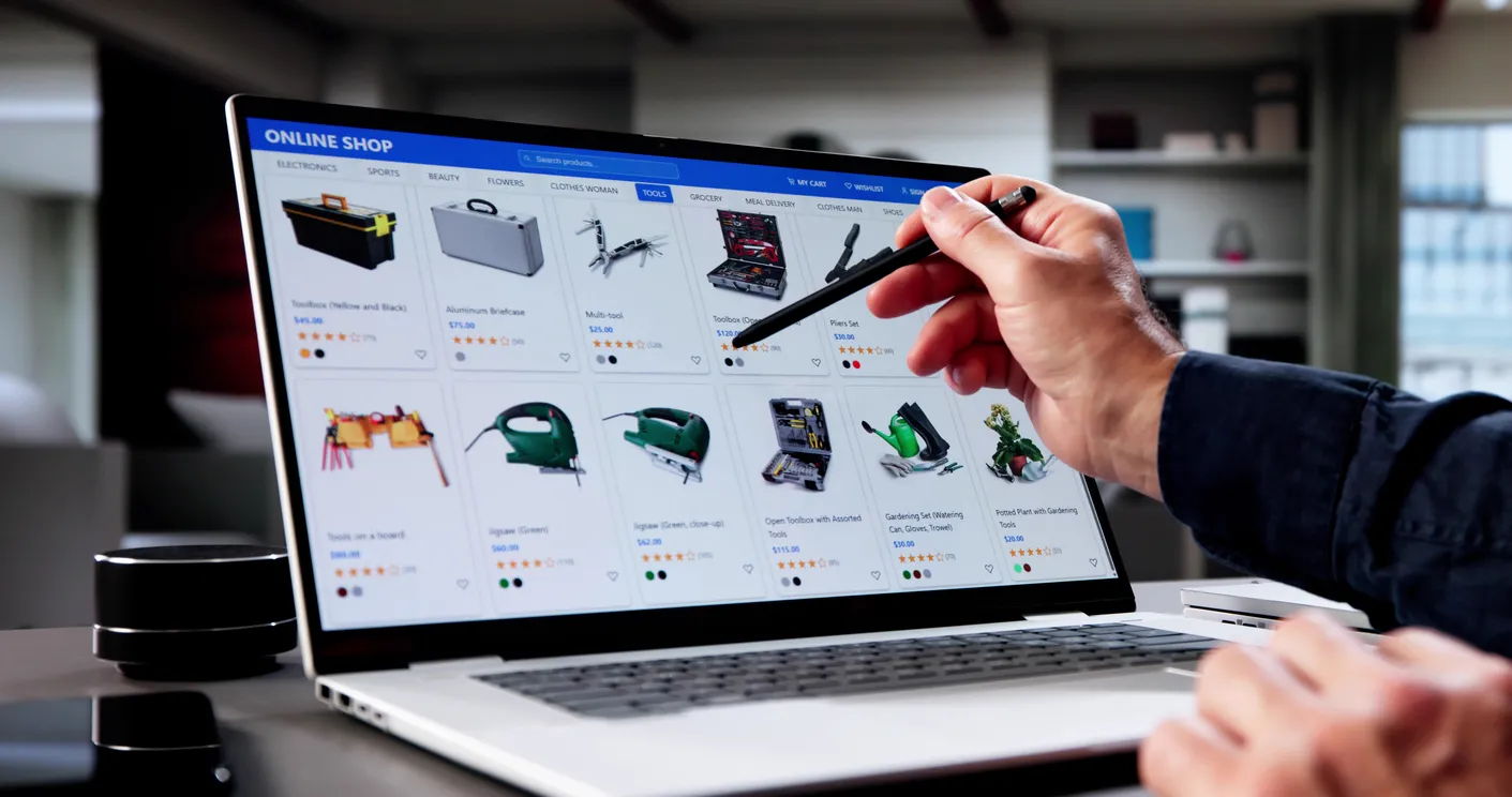 Mano de una persona selalando en una laptop que muestra productos de una tienda online