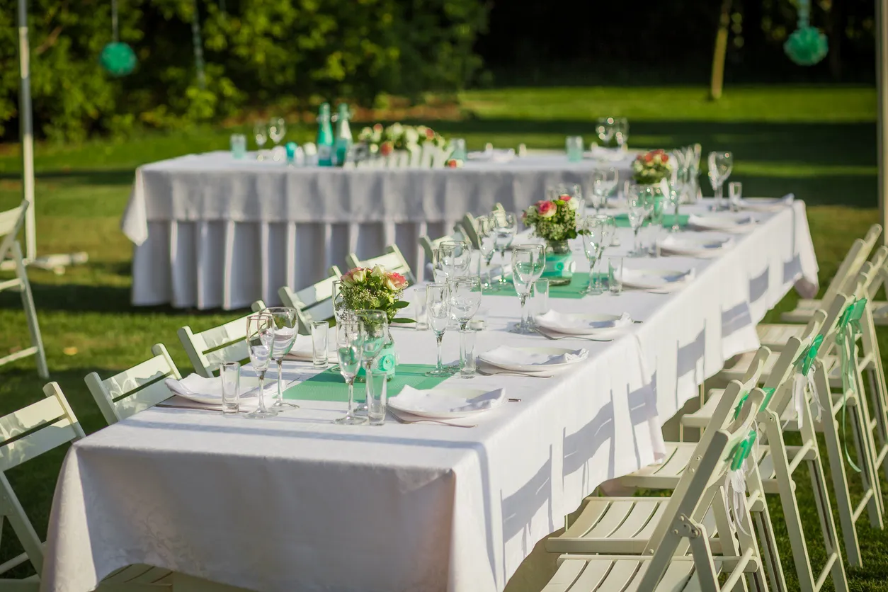 Tablones y sillas adornadas con gran detalle para evento en un gran jadin. 