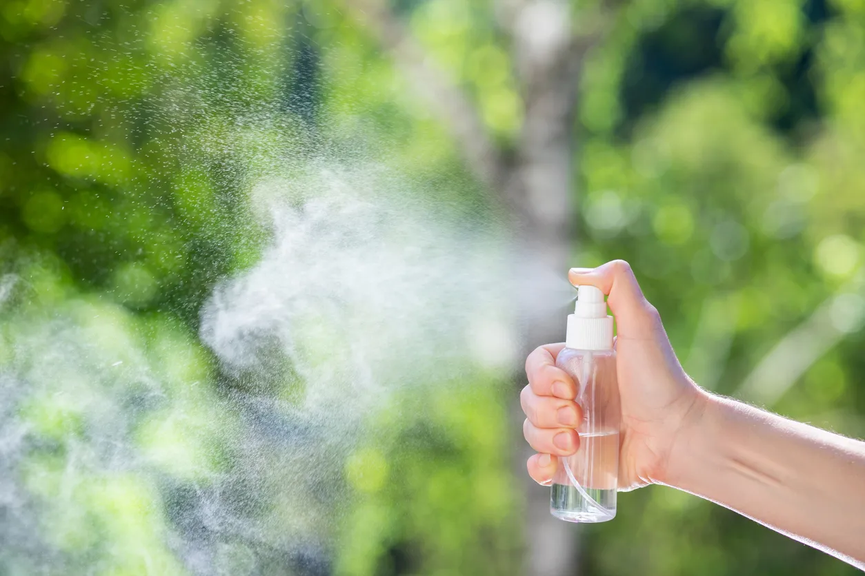 Mano de una persona activando el roseador de un repelente