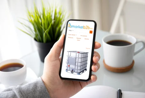 Una mano viendo el portal de market b2b con dos tasas de cafe