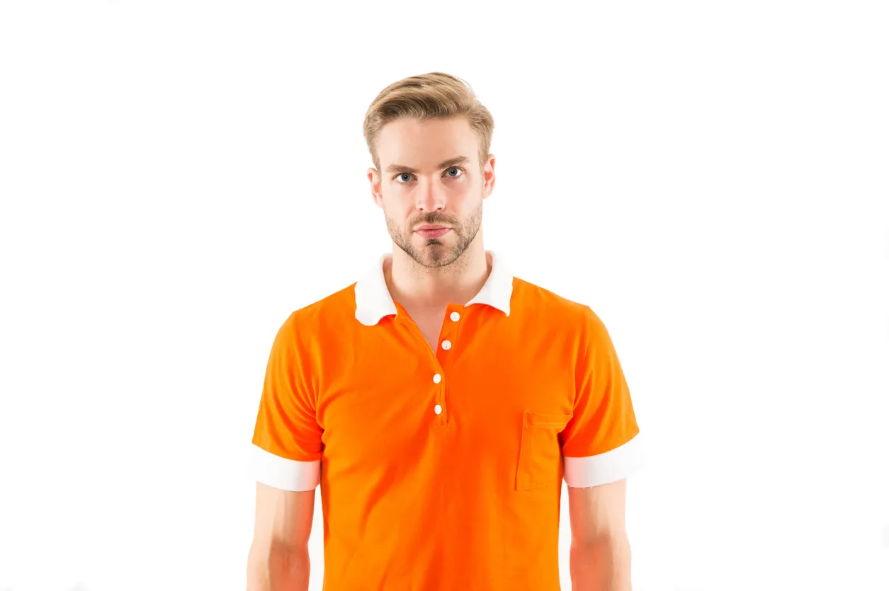 Joven con playera combinada con colores naraja y blanca. 