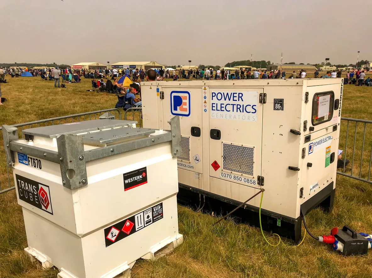 Generador eléctrico portátil al aire libre en un campo en donde se realiza un evento