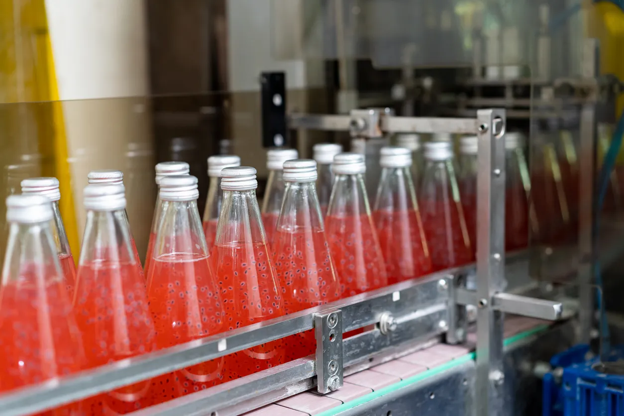 Transportadora de botellas en la fábrica de bebidas. La zeolita ayuda control de dureza y minerales para perfiles específicos