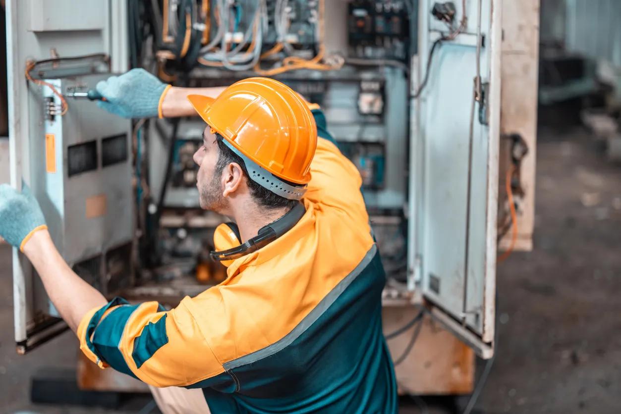 El técnico electricista realiza una revisión en gabinete electrico