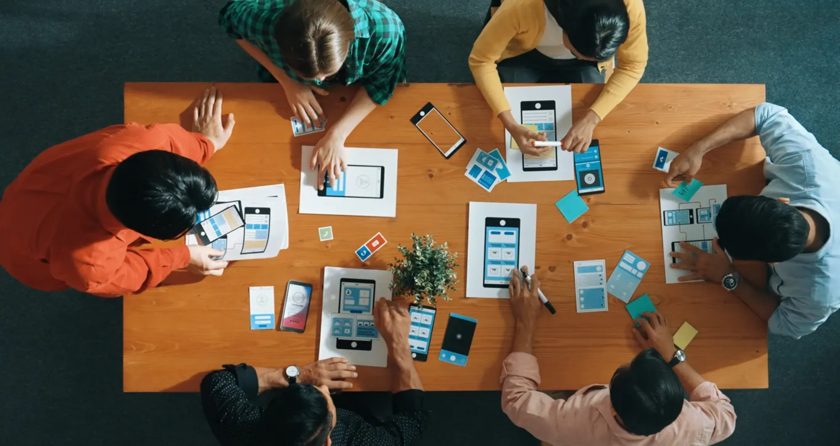 Jóvenes en una mesa diseñando un celular