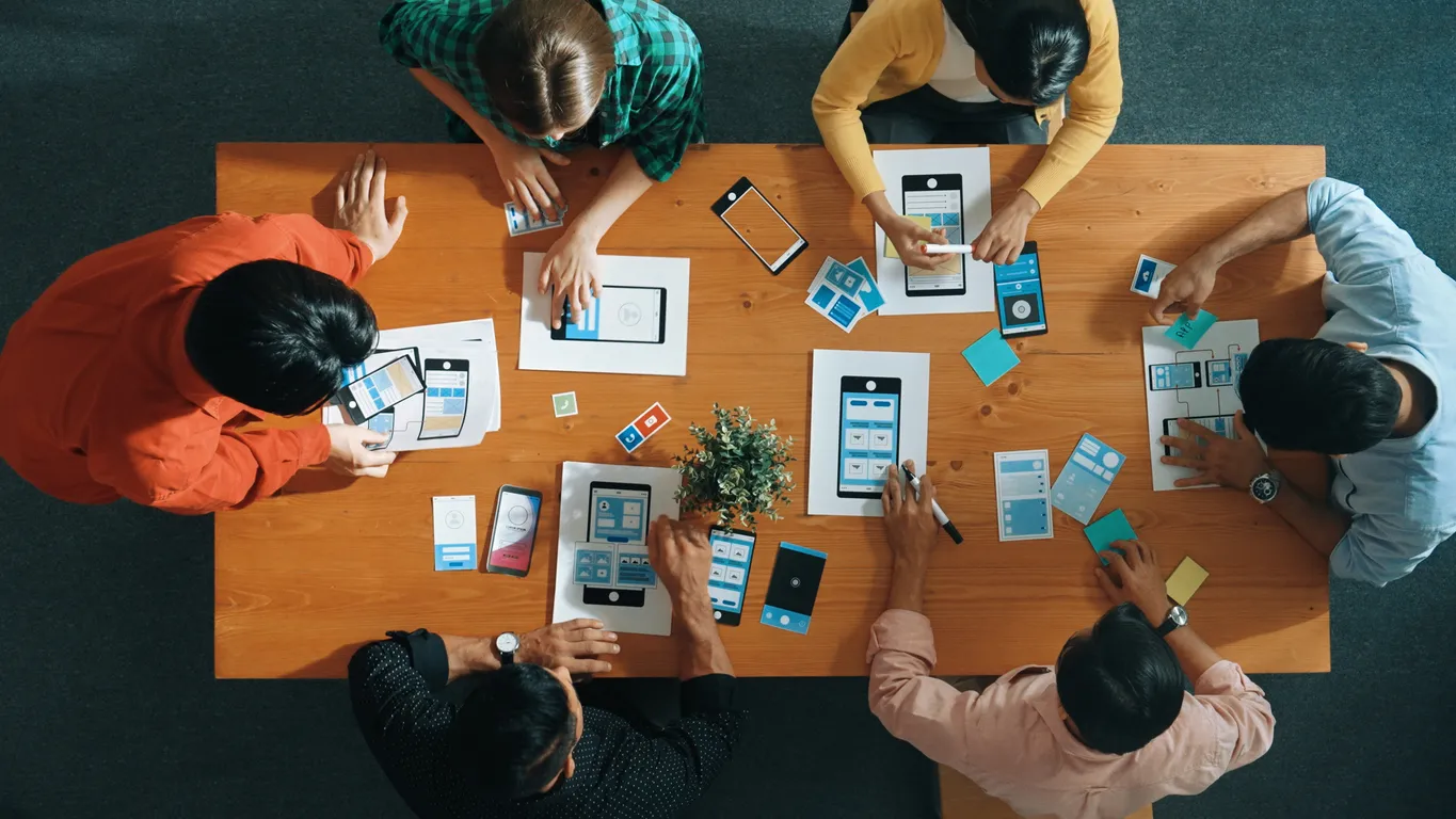 Jóvenes en una mesa diseñando un celular