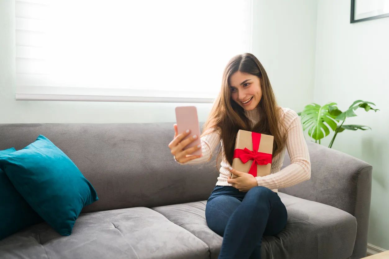 Mujer fotografiandose por que tiene un regalo en sus brazos