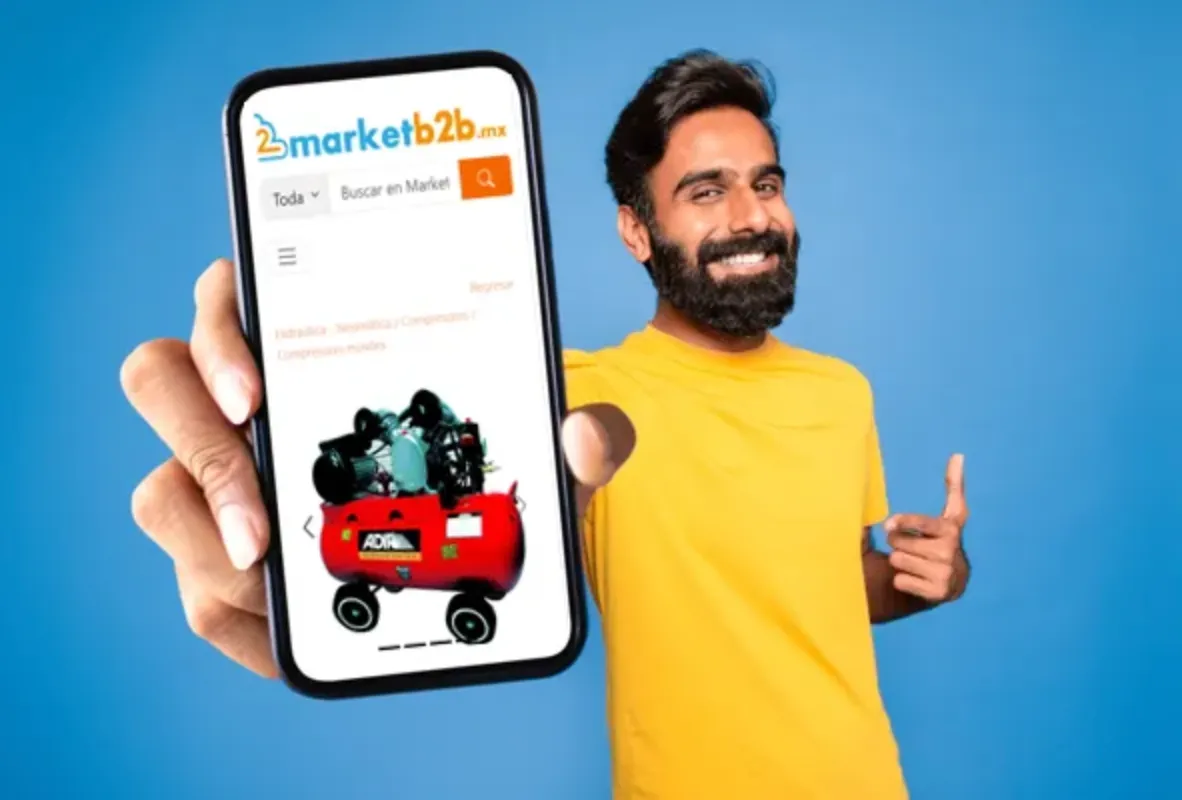 Hombre con barba y playera amarilla enseñando el portal de marketb2b