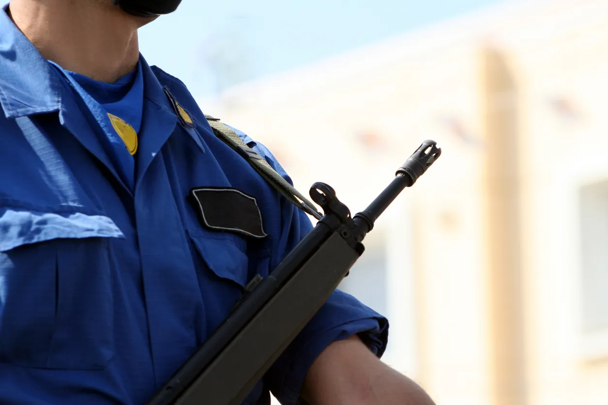 Hombre de seguridad privada con arma en sus manos. Este personal es capacitado para el uso adecuado de estas armas.