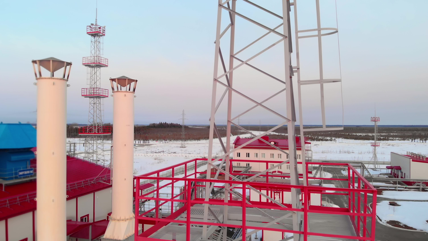 Torre de iluminación de una instalación industrial, un dron vuela sobre una torre de metal. 