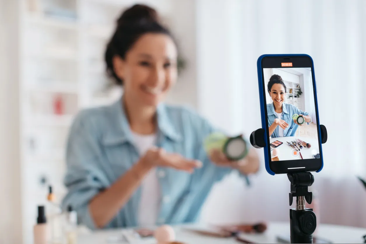Mujer vendiendo su producto a través de la realización de un video con la cámara de un celular 