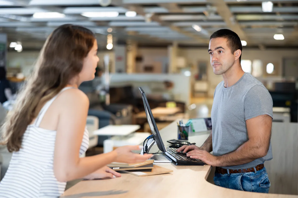 Persona en mostrador de una tienda de productos atendiendo a la clienta