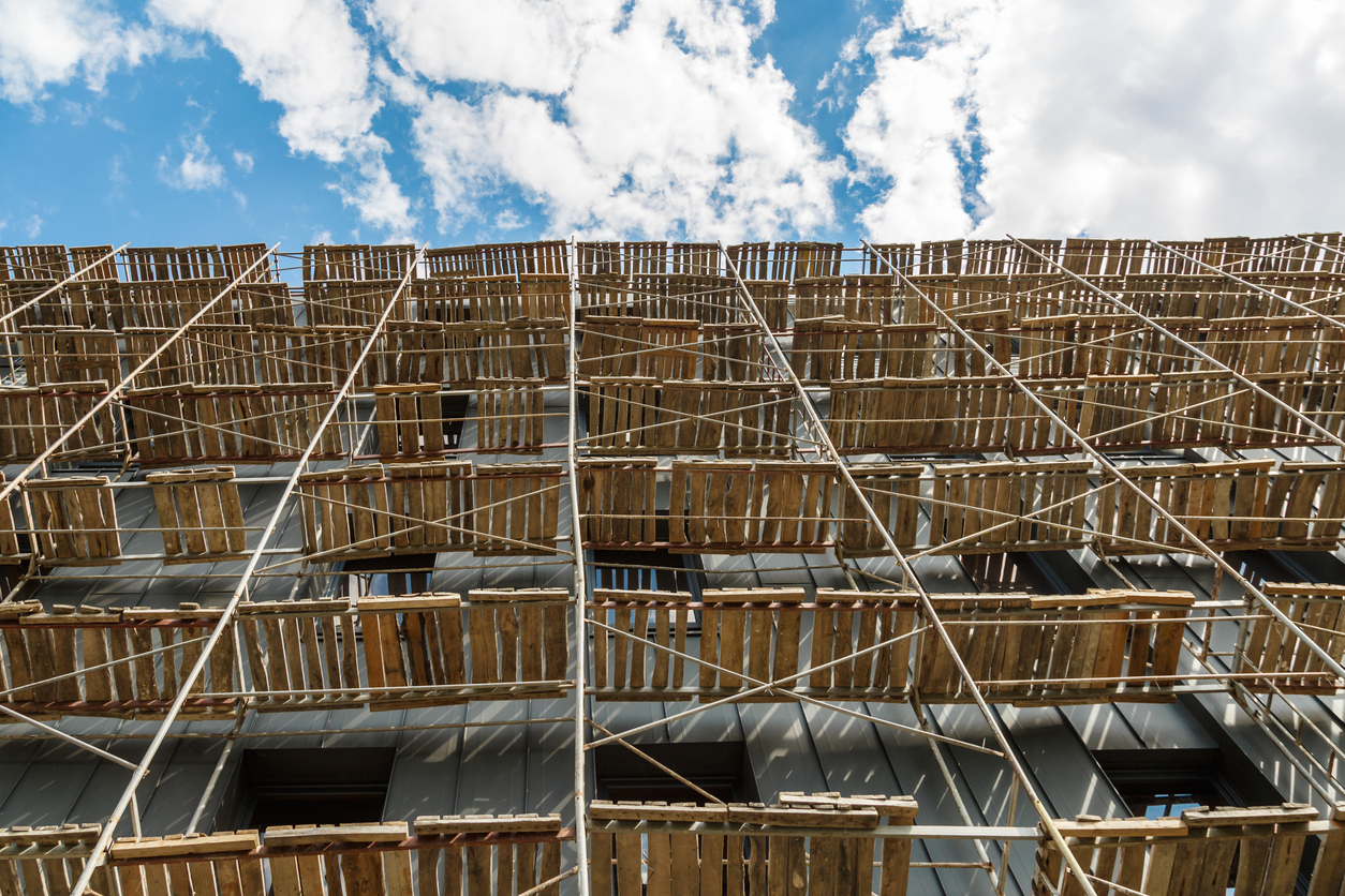 Andamios extensos que proporcionan plataformas para el trabajo en progreso en un nuevo bloque de apartamentos, edificio alto 