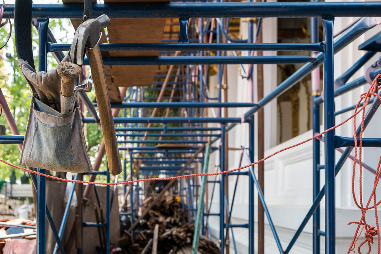 Martillo y herramientas colgados en el almacén del sitio de construcción
