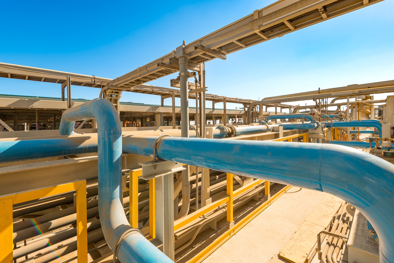 Tuberías y bombas operando en planta desalinizadora de ósmosis inversa en Chile bajo un cielo azul 