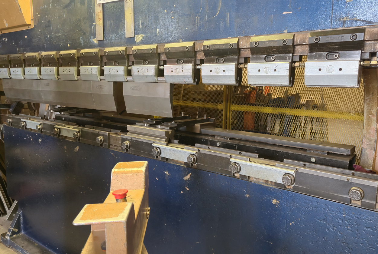 La máquina dobladora funciona con placas de metal pesado en el taller 