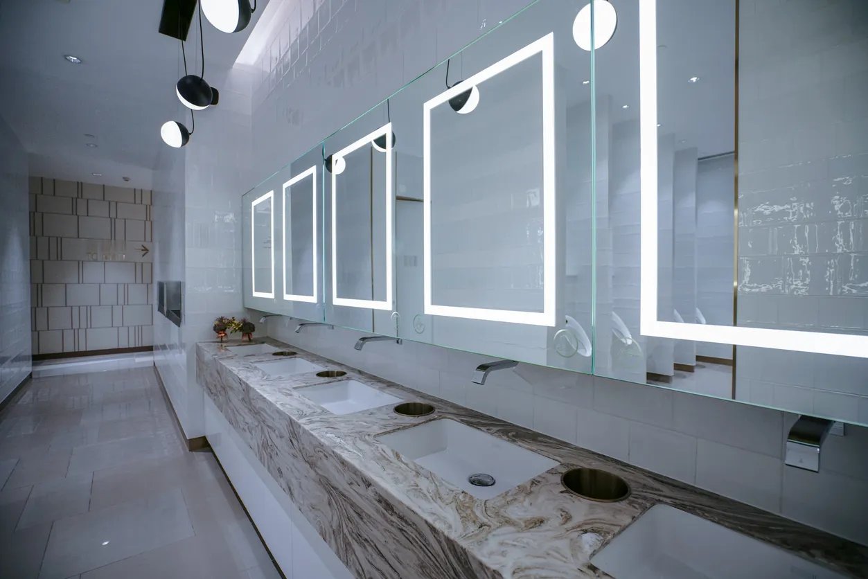 Enorme baño con barra para lavabos y espejos con iluminación