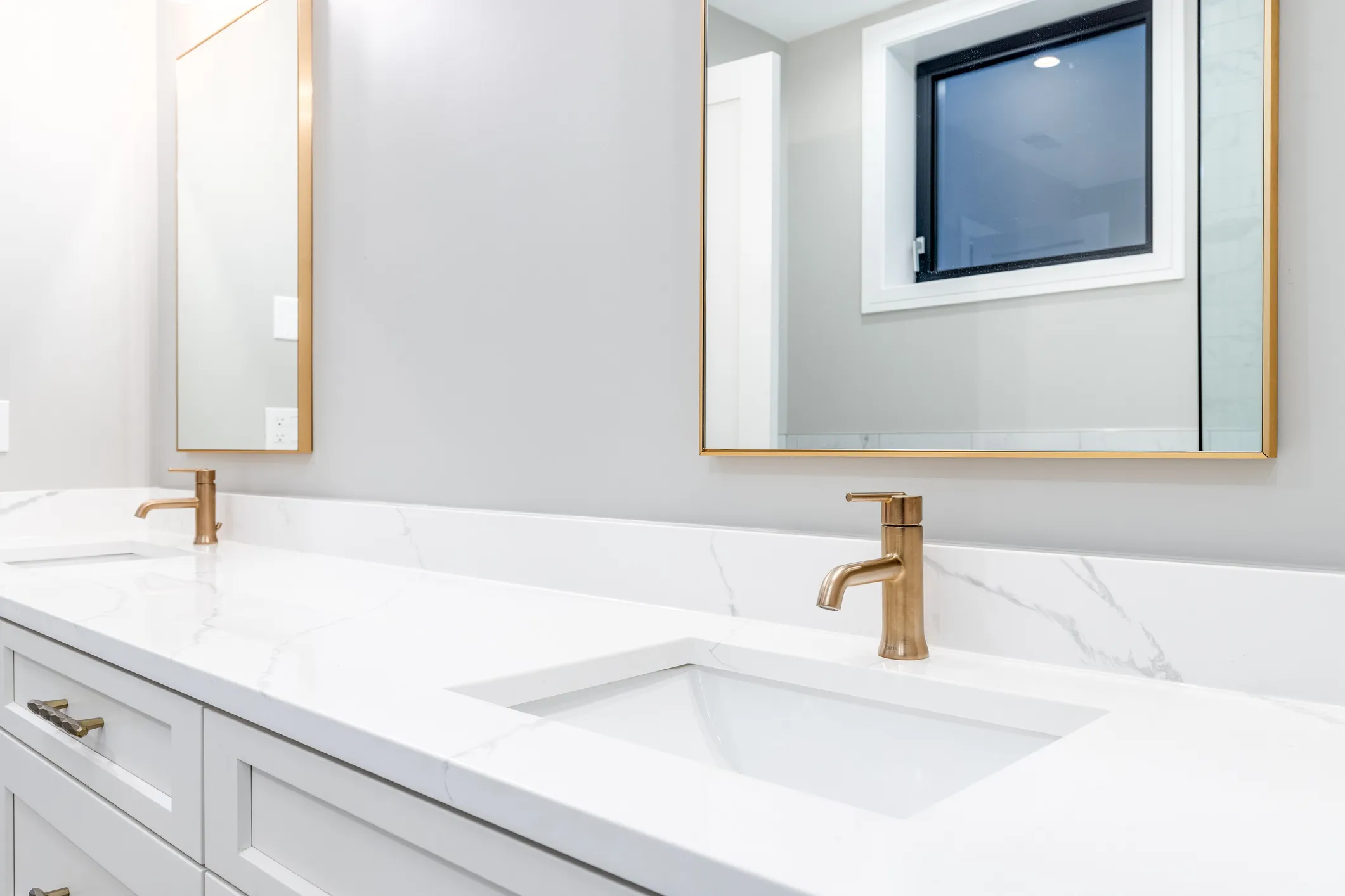Hermoso baño en cerámica blanca con accesorios para baño dorados. 