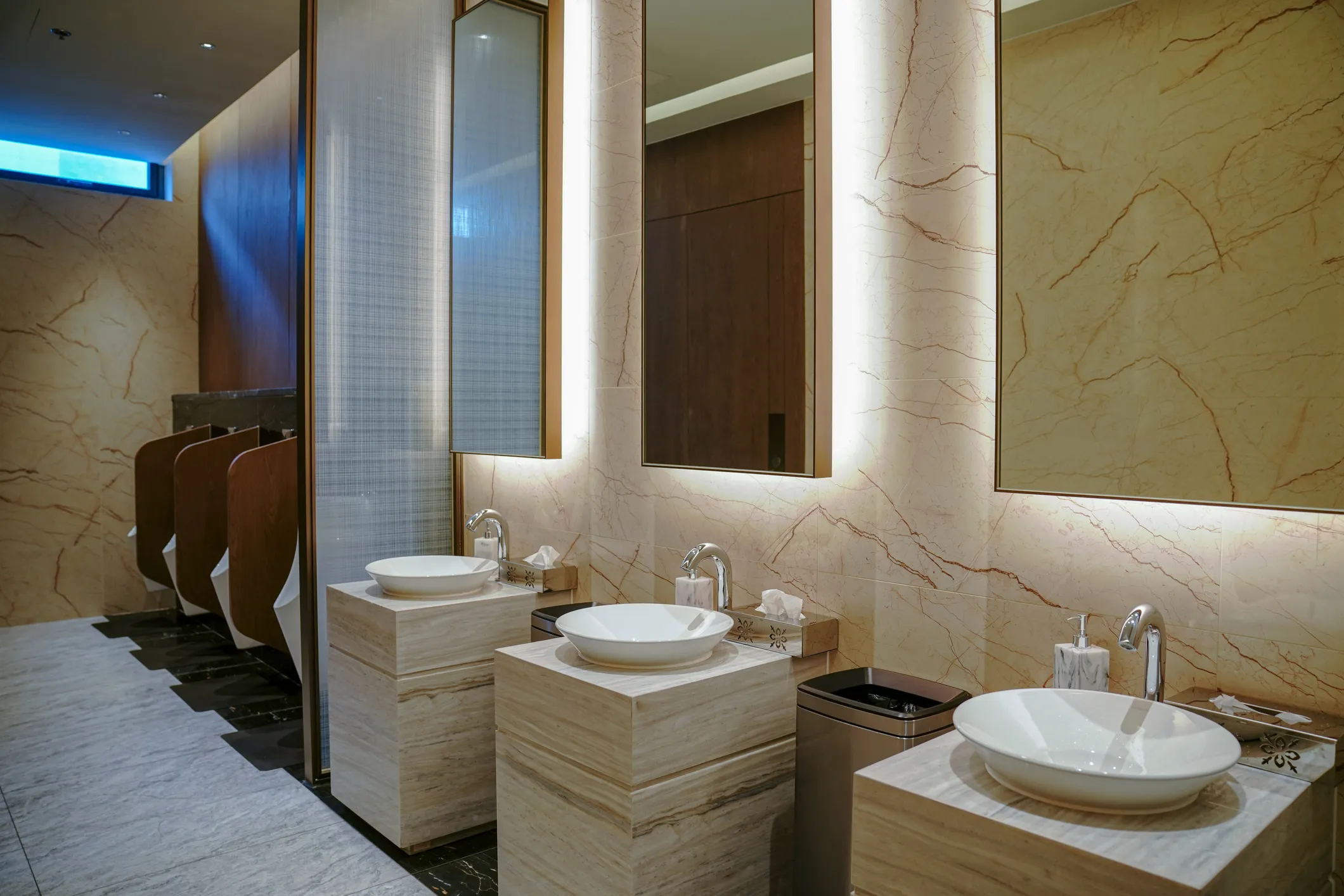 Baños públicos que muestran grandes espejos con luz.