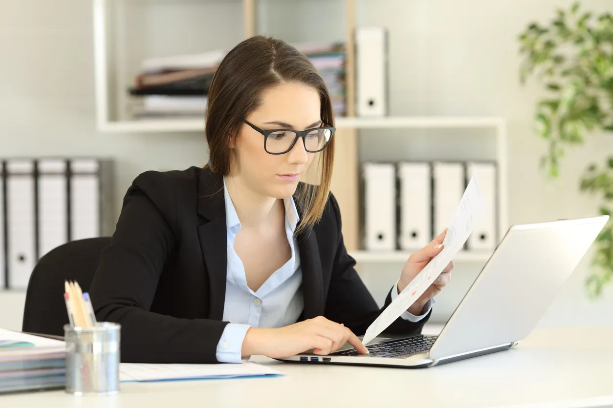 Mujer en oficina frente a laptop trabajando, Contadores y contadoras son los que se encargan en calcular el costo de ventas