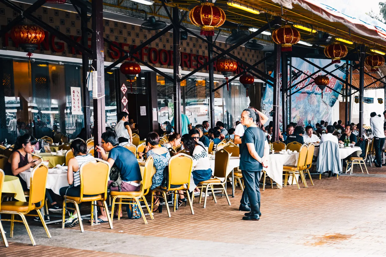 Restauante con una gran cantidad de gente en espacio abierto y gran techo. Existen Air Cooler con capacidad para estos lugare