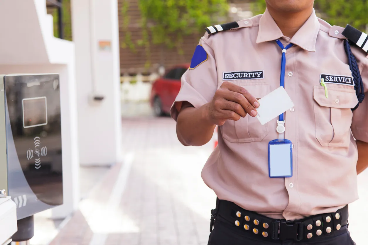 Hombre de seguridad privada en el acceso al estacionamiento de unos condominios