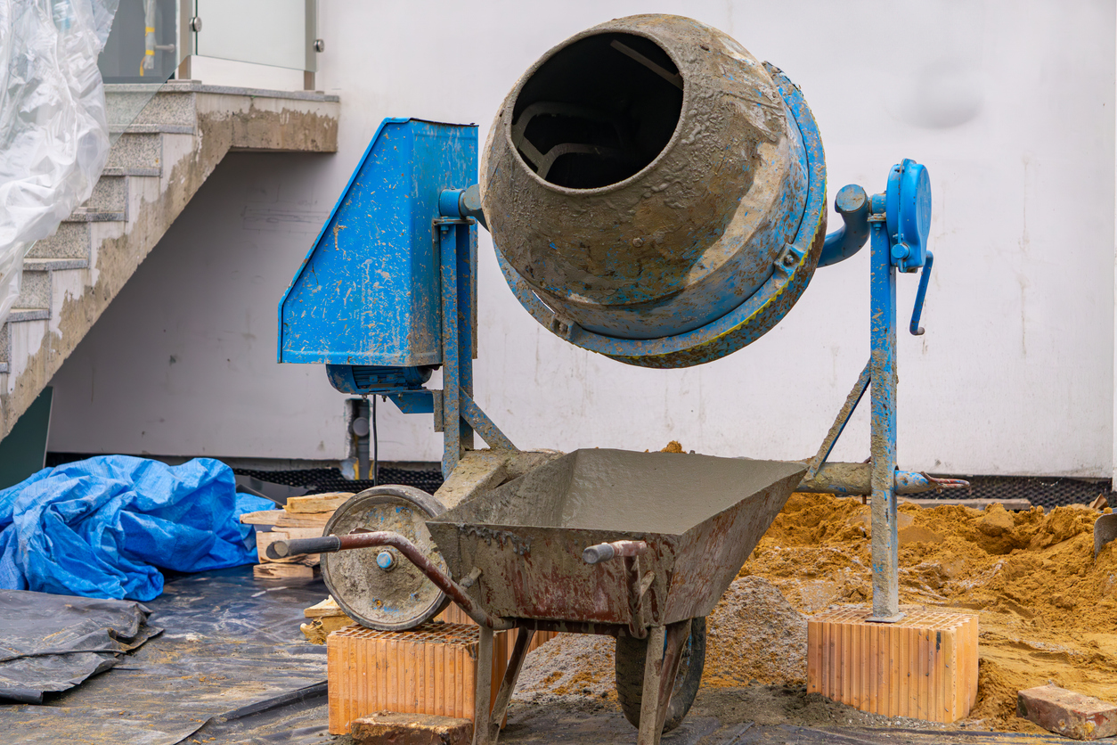 Hormigonera con carretilla sucia para el transporte de mortero en la obra.