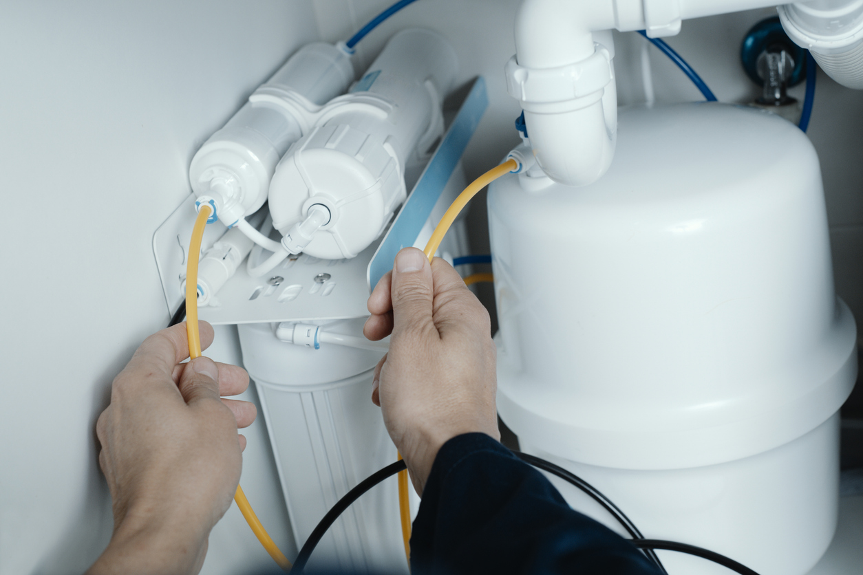 Hombre instalando un sistema de ósmosis inversa