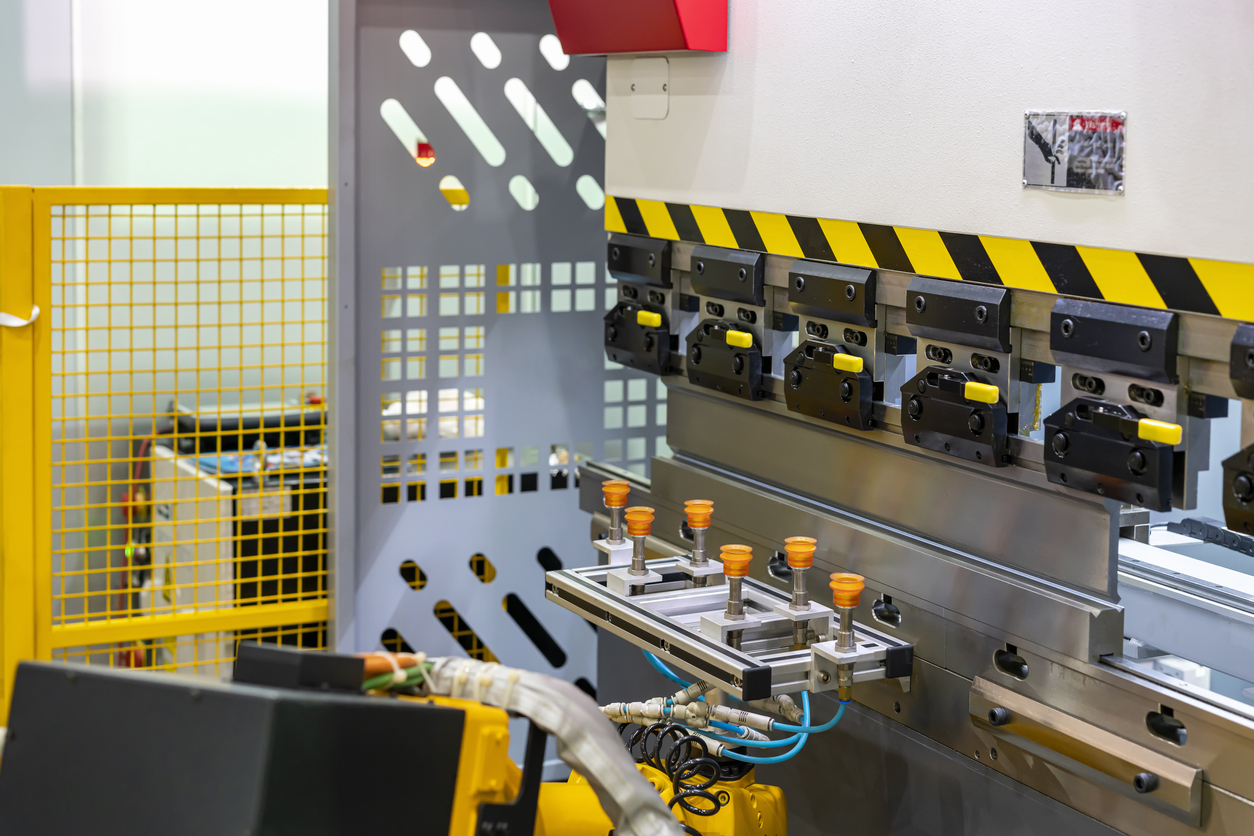 Cierre los dientes de la dobladora hidráulica semiautomática y las manos del técnico atrapan la lámina de metal