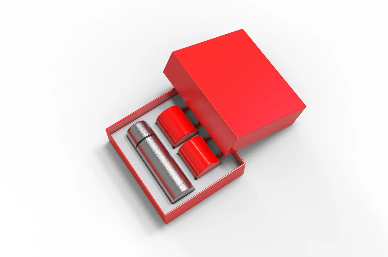 Matraz de acero en blanco con dos tazas de café en una caja para colocar la marca. De los mejores artículos publicitarios