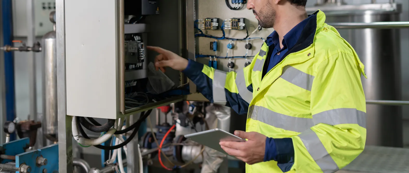 Ingeniero trabajando en gabinete de control en planta de fabricación