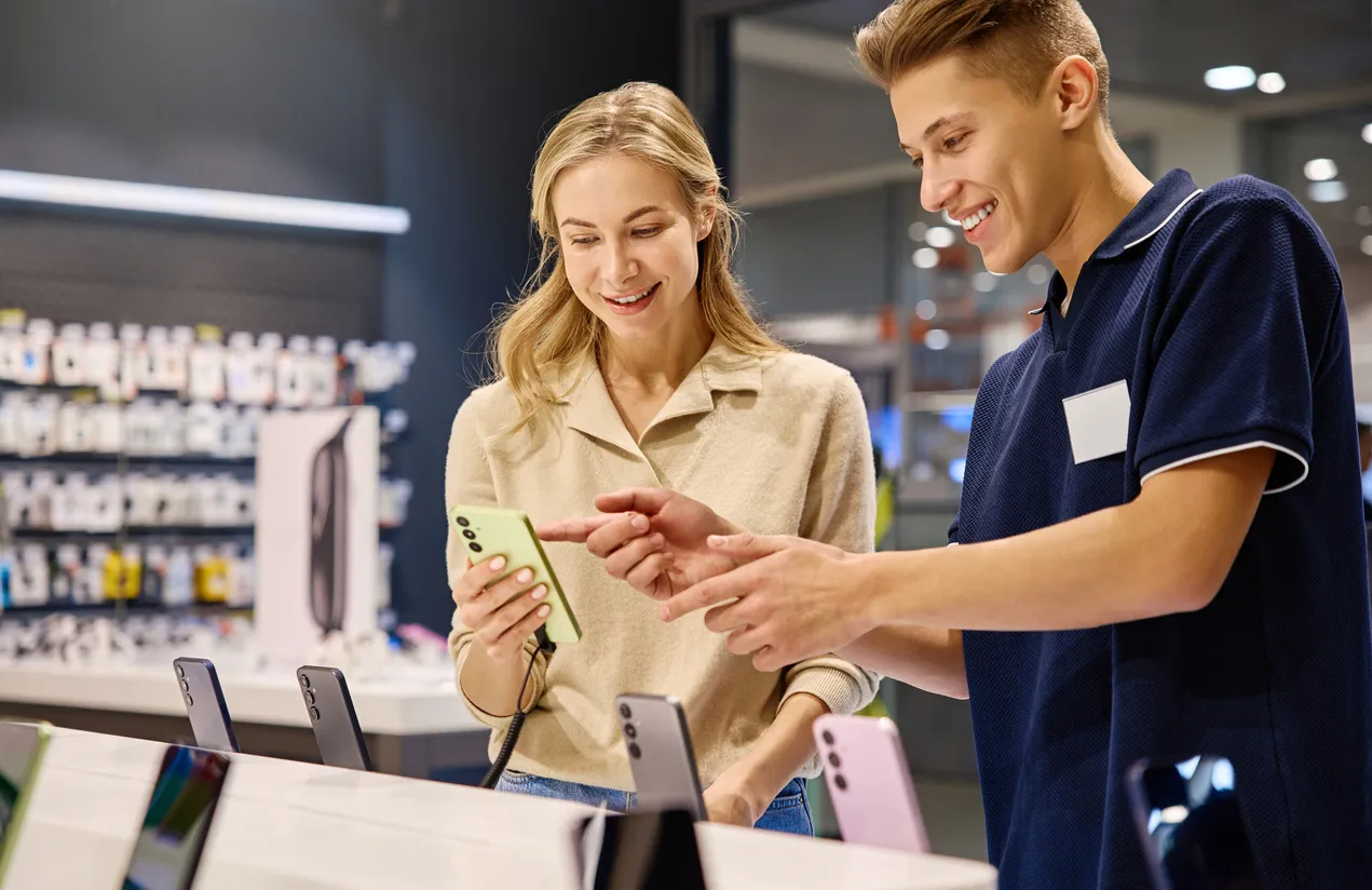 Cliente y vendedor participan activamente en el proceso de selección de teléfonos inteligentes en una tienda minorista