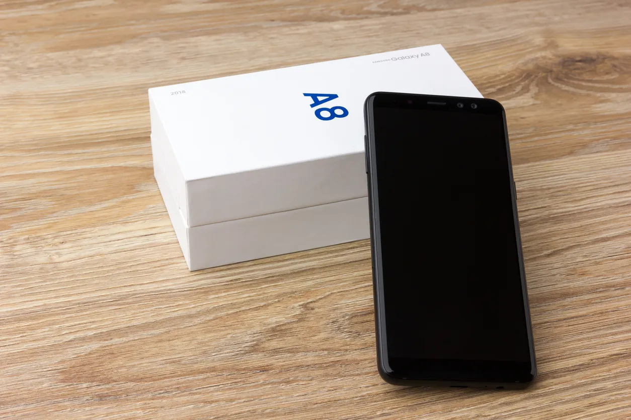 El Samsung Galaxy A8 yace sobre una mesa de madera Celular del 2018