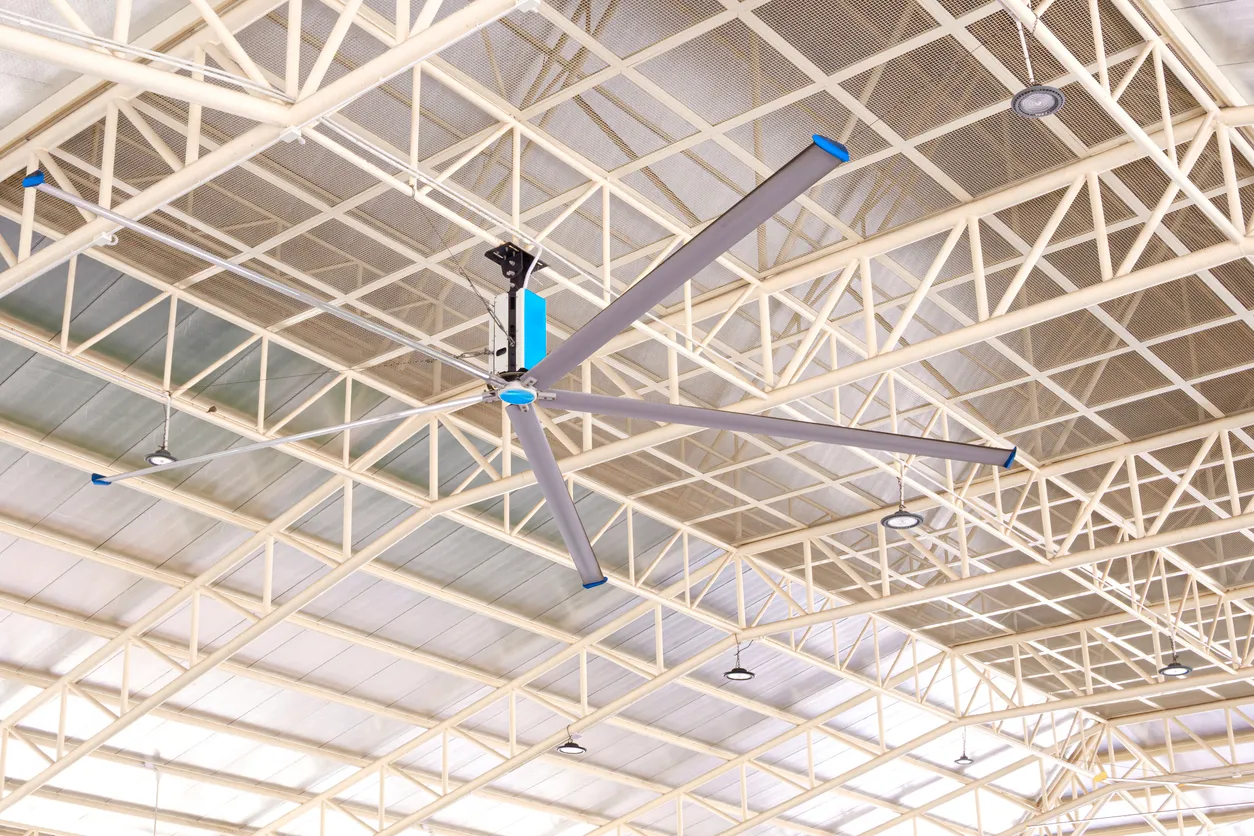 Ventilador grande HVLS bajo estructura de vigas de techo de metal con techo con aislamiento térmico de un gran edificio