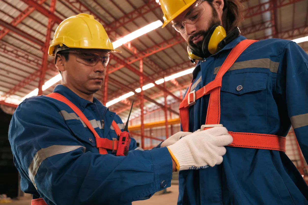 Equipo de ingenieros o trabajadores poniéndose trajes de seguridad y cascos.