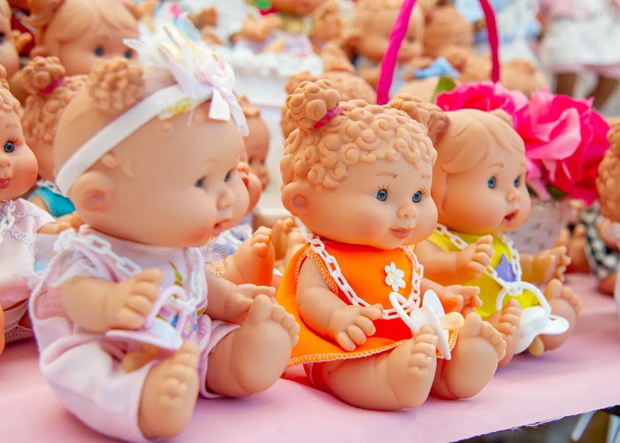 Muñecas de bebé vestidas de colores en tienda de juguetes 