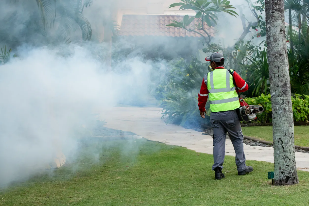 Un hombre usa una máquina fumigadora para matar mosquitos en parques o jardines. Prevención del brote de Zika y dengue.