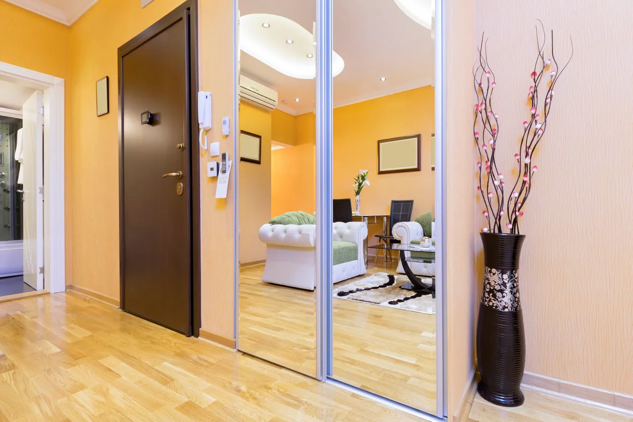 Interior en un lujoso departamente con un gran espejo para acceso a un armario 