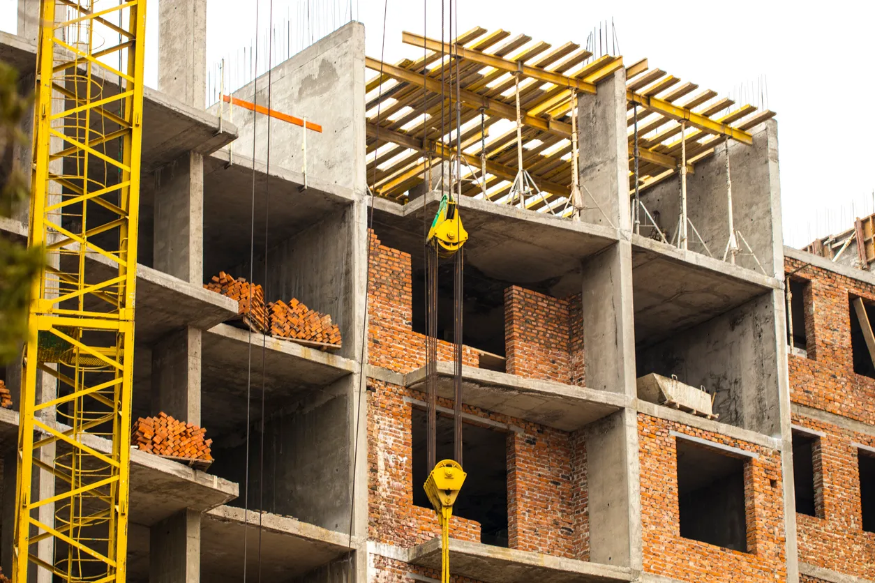 Consturcción de un edificio de departamentos en proceso, con izaje de material a las plantas superiores
