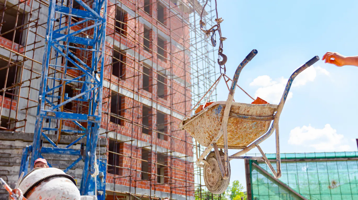 Obra en contrucción usando un malacate para subir material