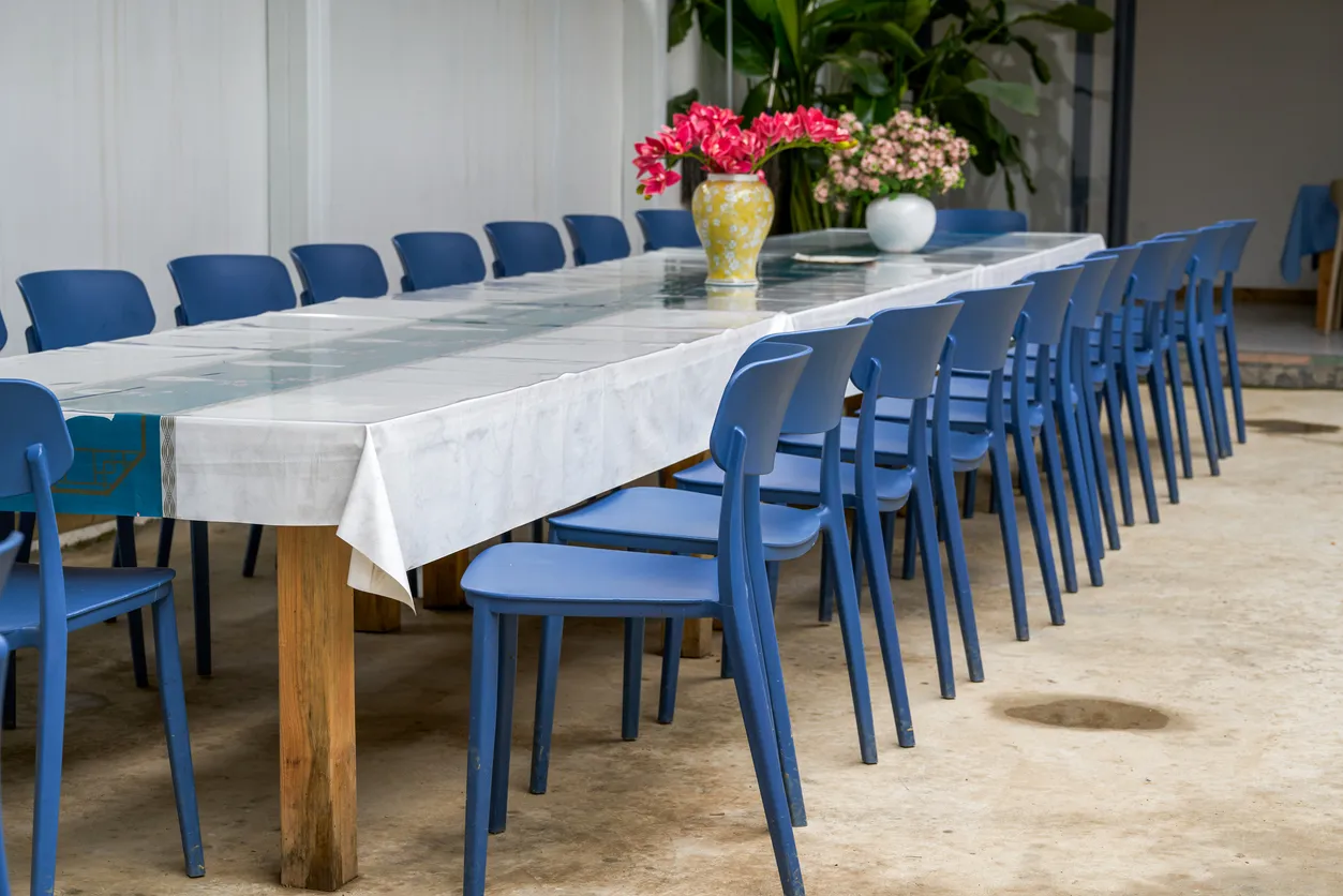Gran cantidad de sillas de plástico azul moderna rodeando una mesa para una reunión